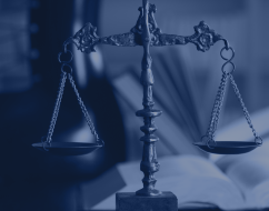 A balance scale in front of an open book, symbolizing justice and law