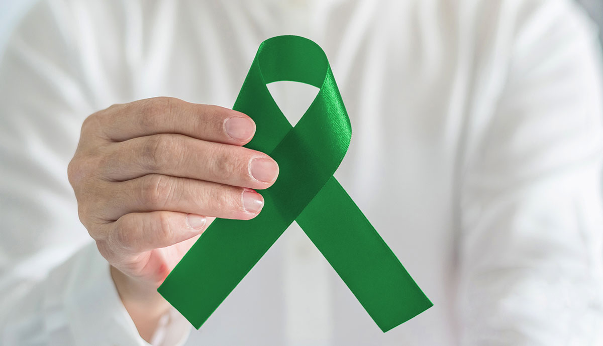 person holding a green cerebral palsy awareness ribon
