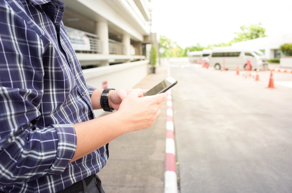 Man with a smartphone waiting for an Uber