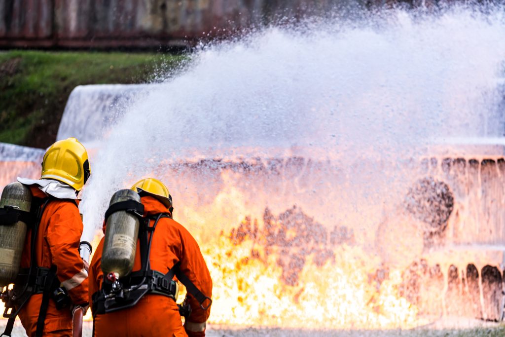 Firefighters using foam on a fire