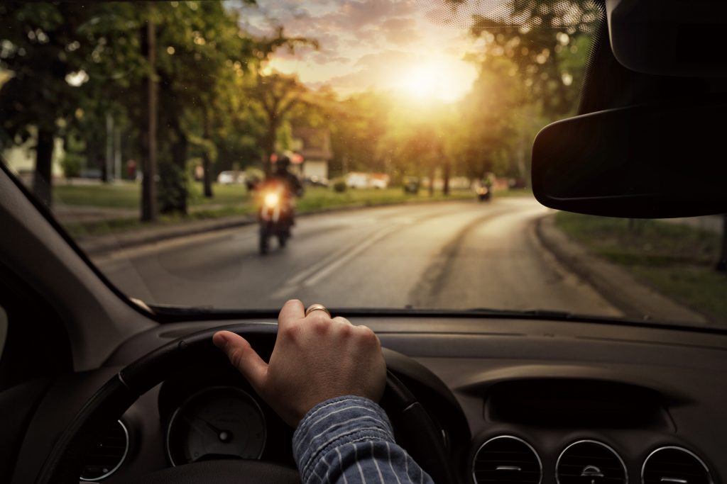 First person perspective driving a car with a motorcycle coming head on