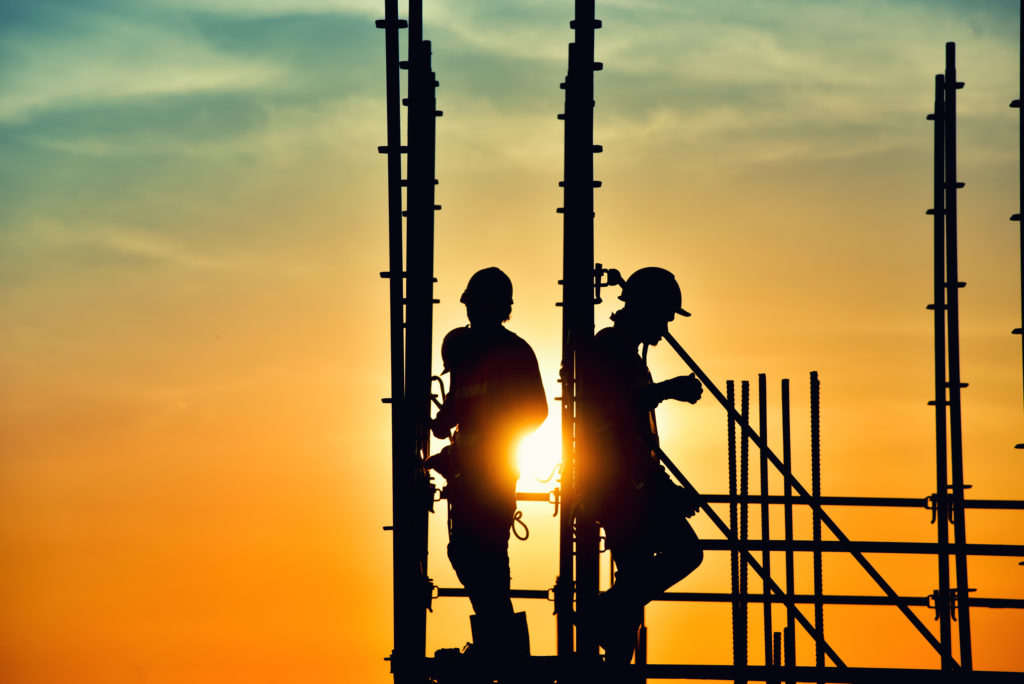 Construction workers on site working on scaffolding.