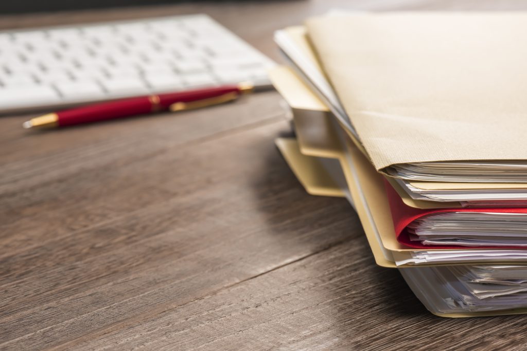 Stacks of papers and folders on a desk