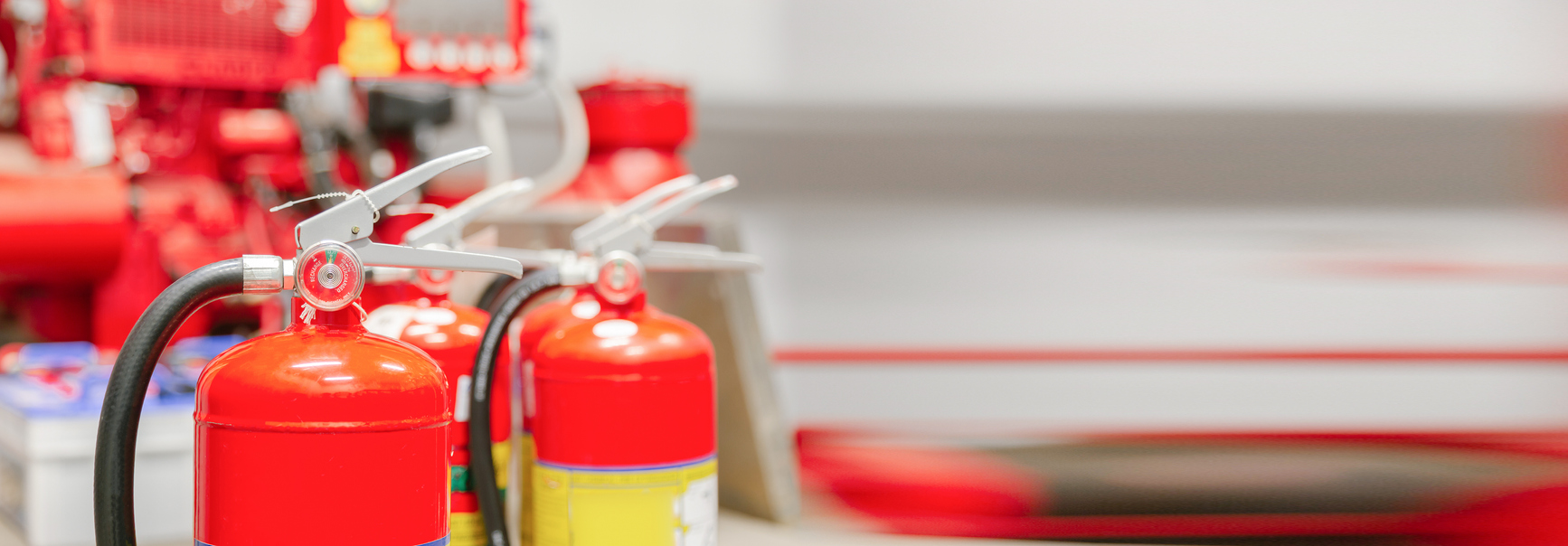 Several fire extinguishers in front of a firehose