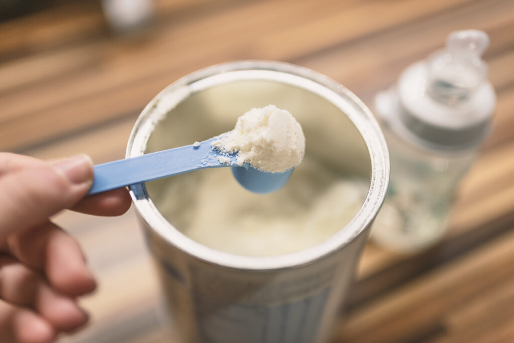 Powdered baby formula in a measuring spoon