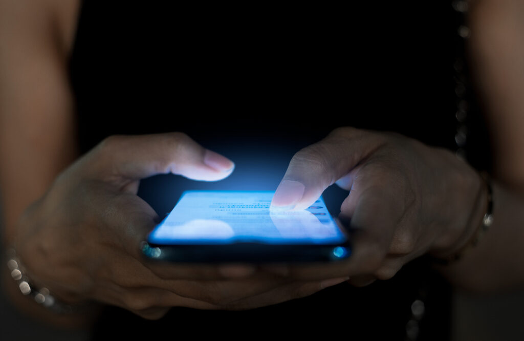 A close up of a woman's hands using a smartphone to view social media